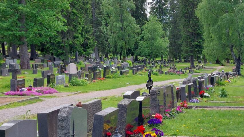 Hautakiviä ja puustoa Heinolan hautausmaalla kesällä.