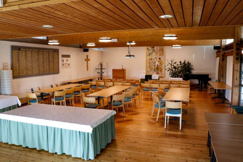 Pöytiä ja tuoleja seurakuntasalissa.