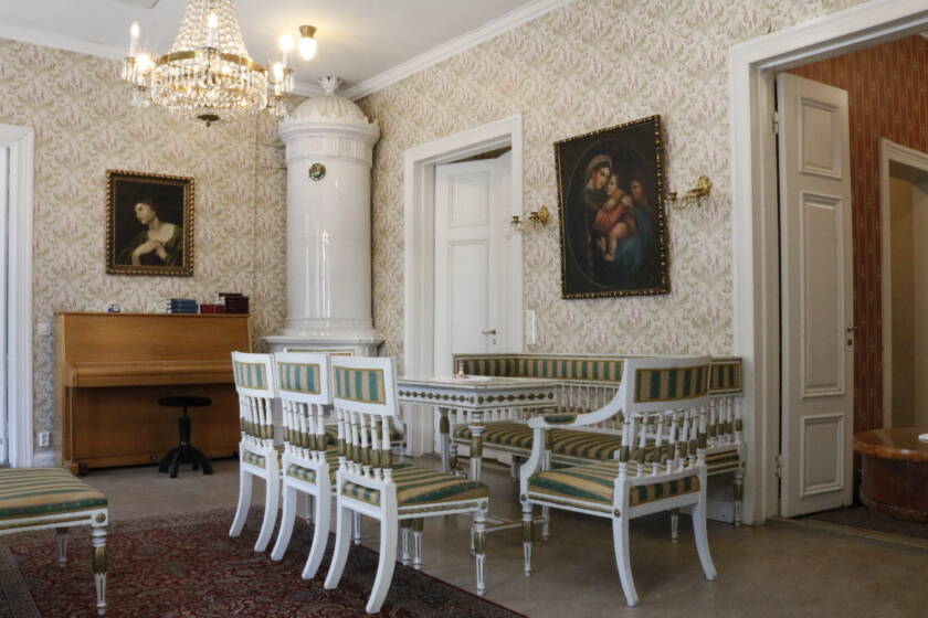 Vanhan pappilan salissa on 1800-luvun huonekaluja, pyöreä kaakeliuuni ja seinällä maalauksia. Katossa kristallikruunu.