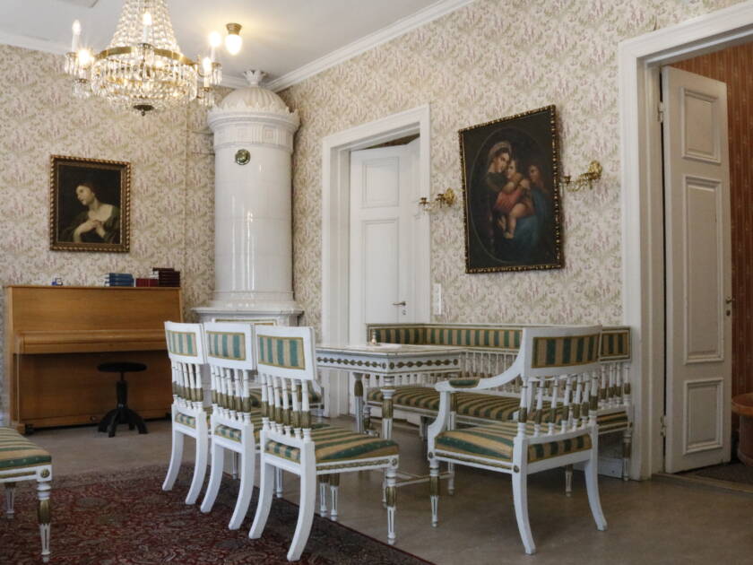 Vanhan pappilan salissa on 1800-luvun huonekaluja, pyöreä kaakeliuuni ja seinällä maalauksia. Katossa kristallikruunu.