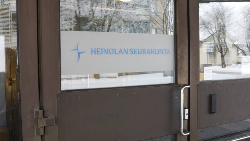 Ovessa tarra jossa on risti ja teksti Heinolan seurakunta.