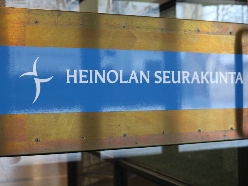 Ovessa tarra jossa on risti ja teksti Heinolan seurakunta.
