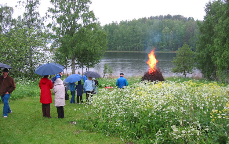 Ihmisiä juhannuskokkoa katsomassa