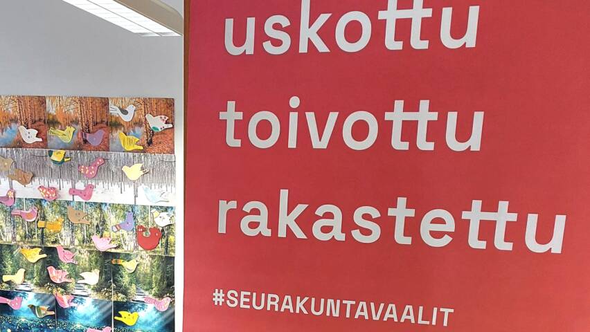 Oranssi juliste, jossa on teksti "uskottu, toivottu, rakastettu" ja "seurakuntavaalit".